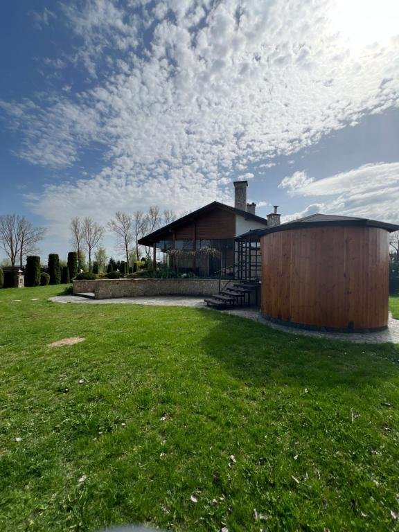 Boczny widok dworku z drewnianą altaną / jacuzzi