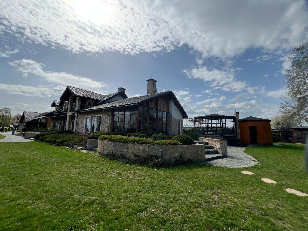 Kamienny dworek Siwy Las — widok frontalny z ogrodem i altaną